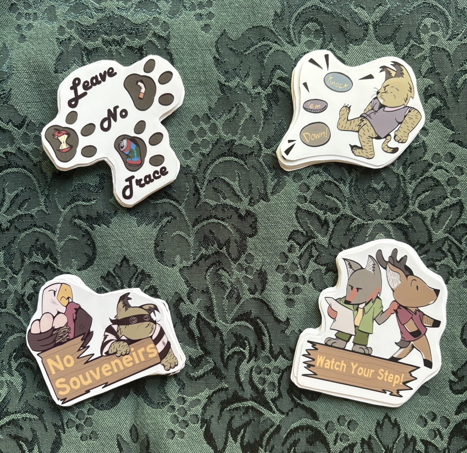 Picture of 4 different stickers depicting many forest animals and trail signs