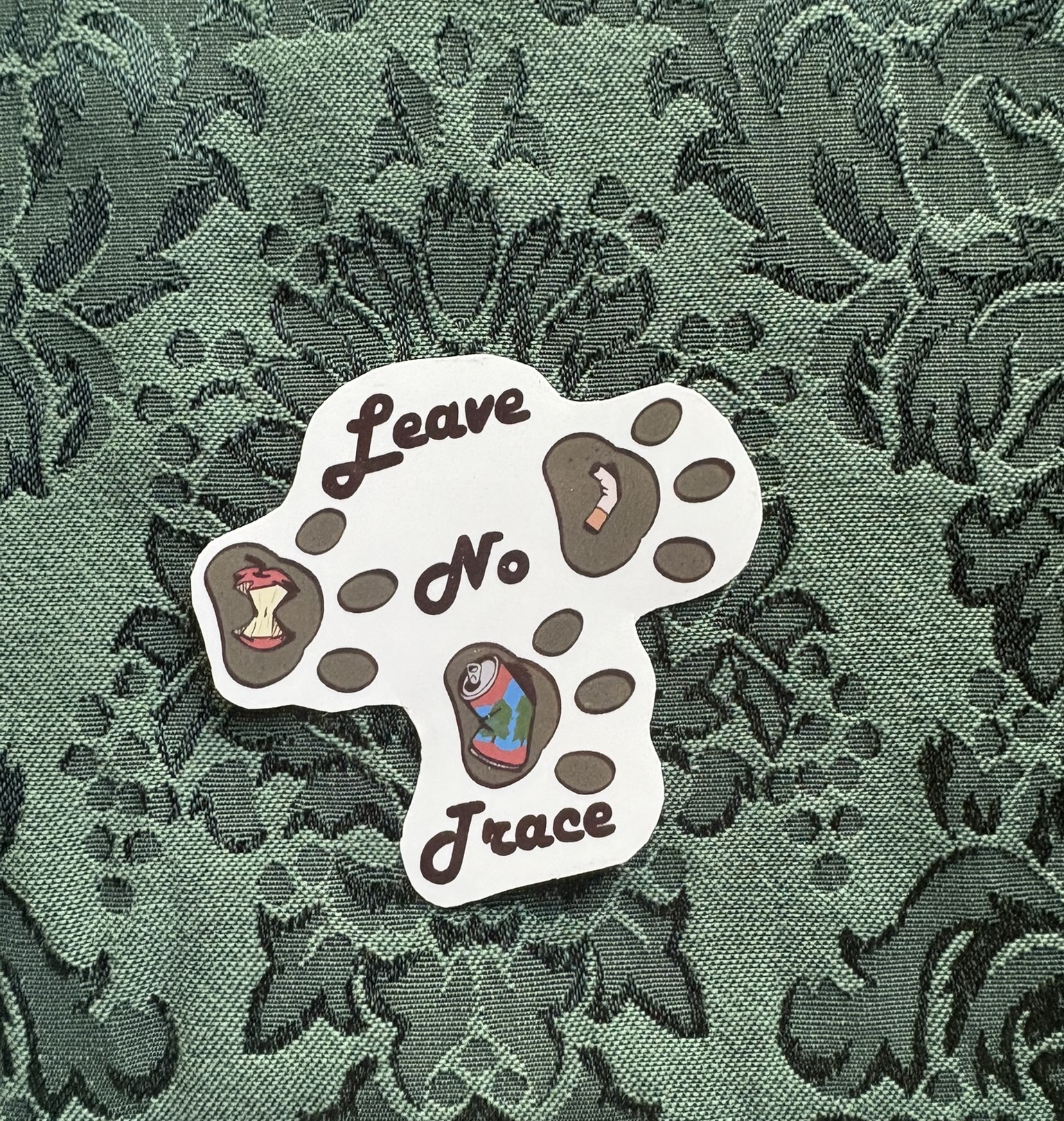 Picture of bear prints with different pieces of trash inside them. Text reads LEAVE NO TRACE.