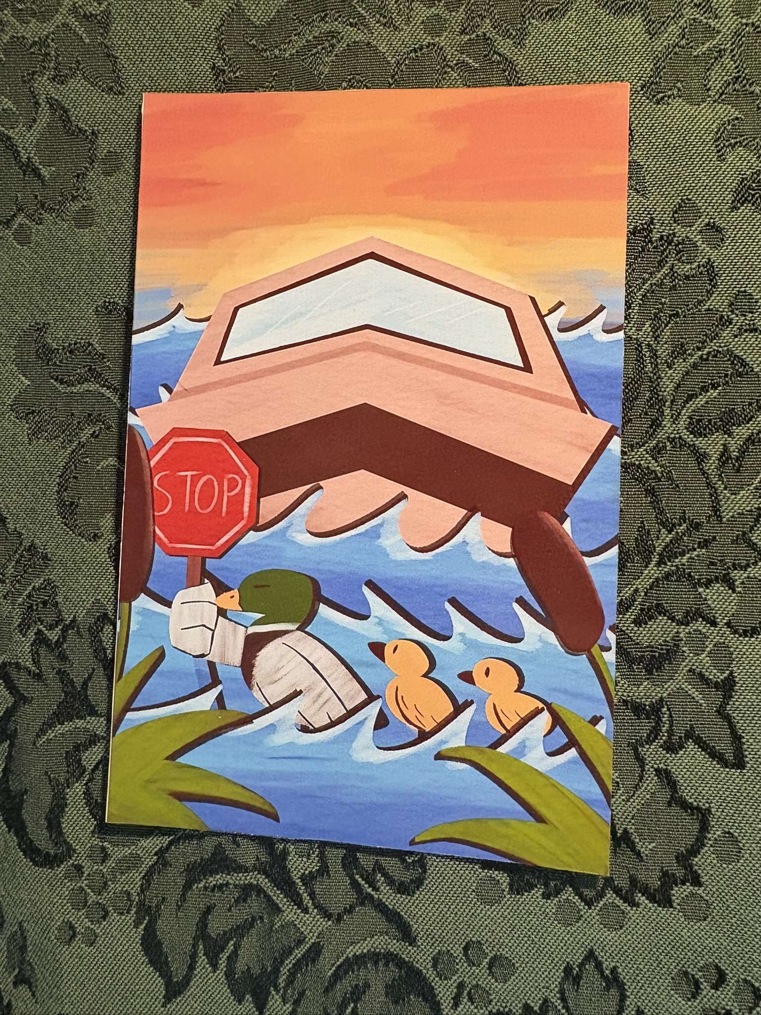 A 4 by 6 inch, glossy poster print. It shows three ducks crossing a lake, one holds a stop sign in its hand. Behind the sign is a boat waiting for the ducks to pass.