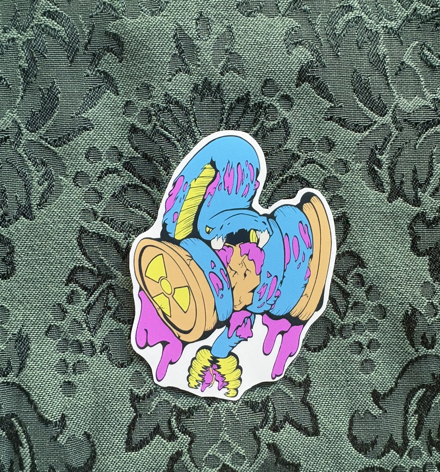 Picture of a rattlesnake biting into a radioactive can. Parts of its skin are peeling off.